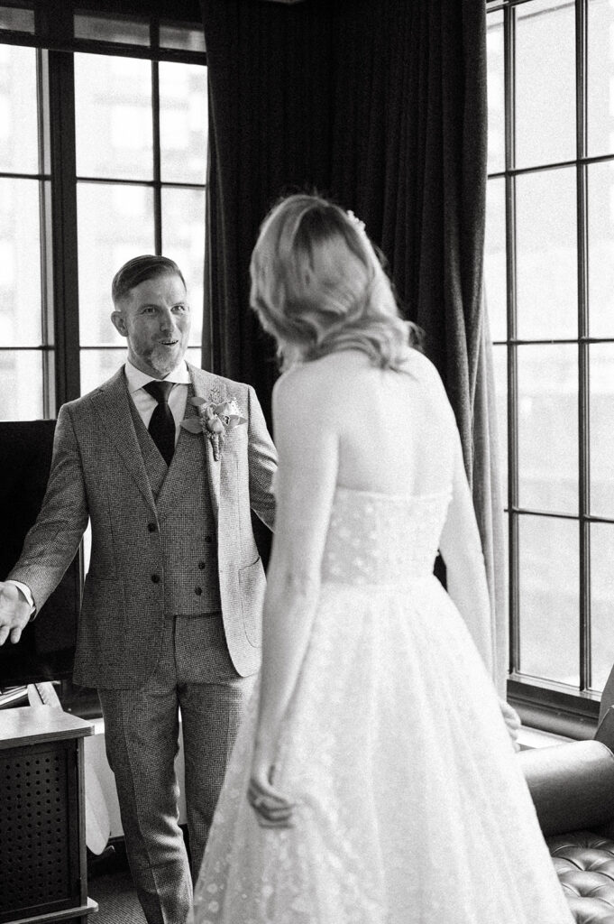 The groom sees the bride during their first look and has a surprised expression on his face