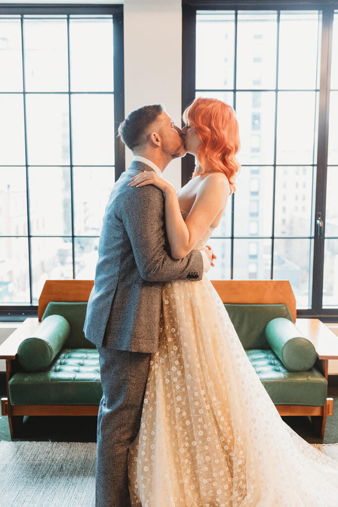 Bride and groom kissing in the hotel room during their first look.