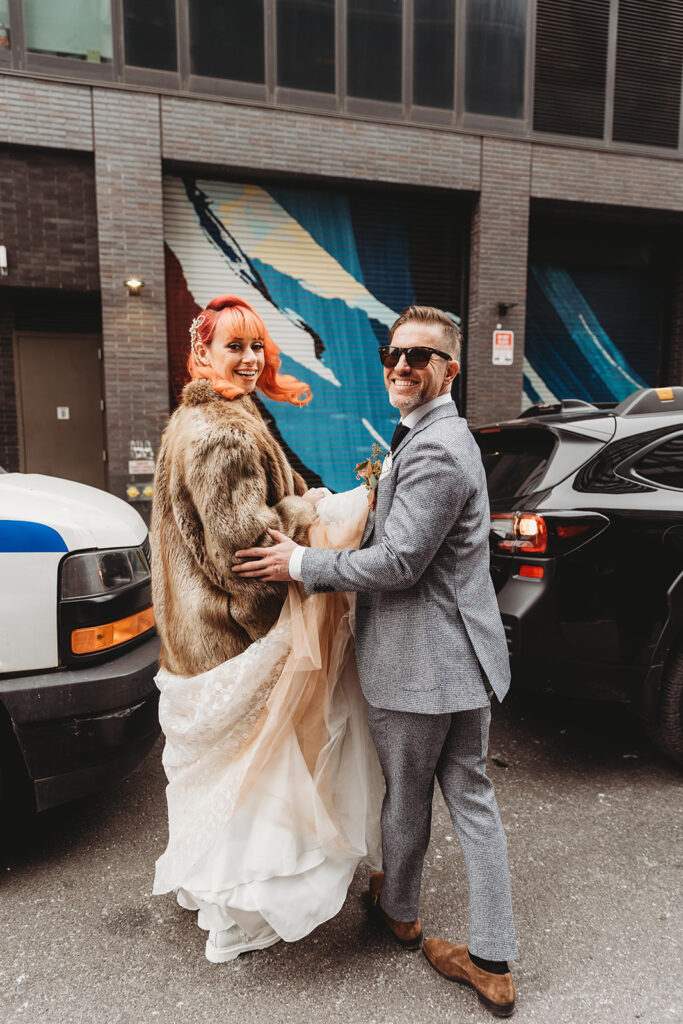 Bride and groom in the street turned around in a candid to look at photographer